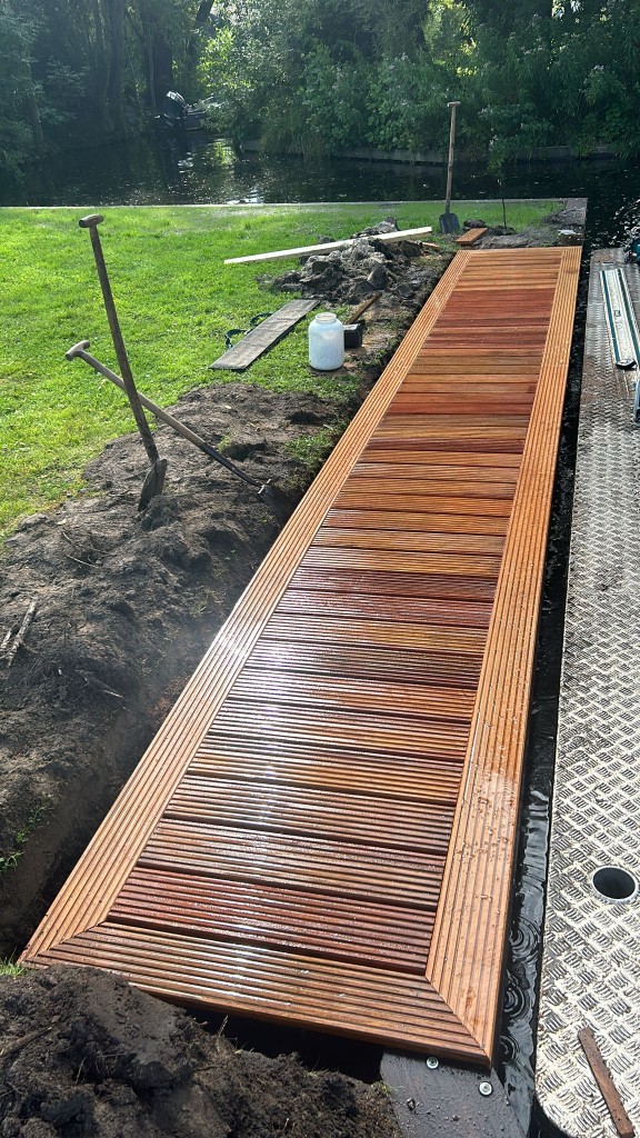 Houten dekpad langs het water in aanbouw
